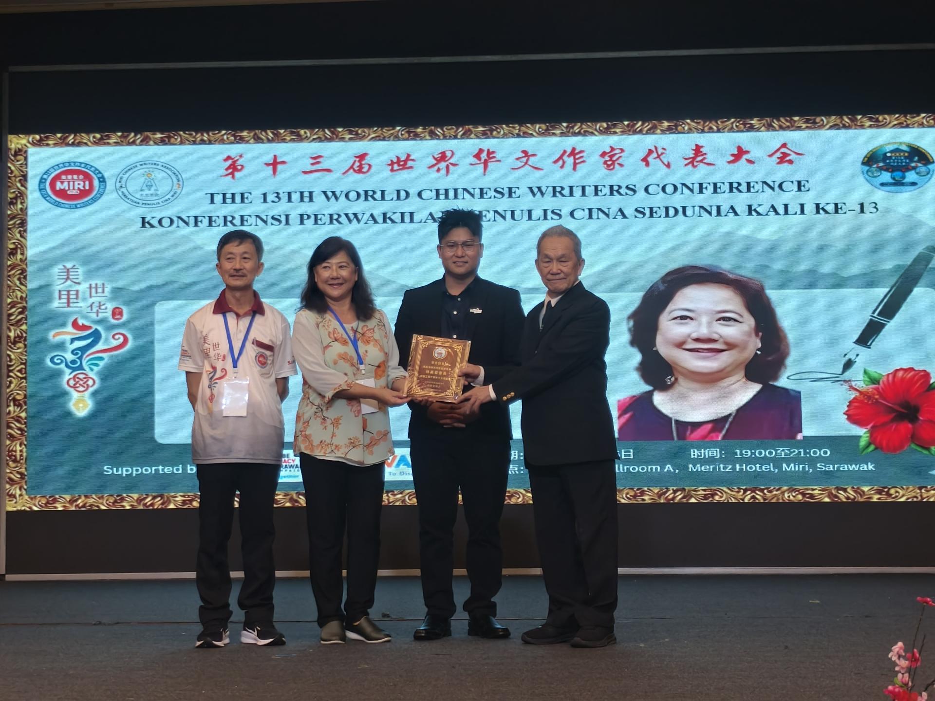 大会主席孙德安（右）在主宾赵俊文代表邹梓建（中）见证下，颁授2024世华大会十大贡献奖给获奖者南美洲华文作家协会会长林美君。左为美里笔会主席兼第13届世界华文作家代表大会筹备会主席许敬平。