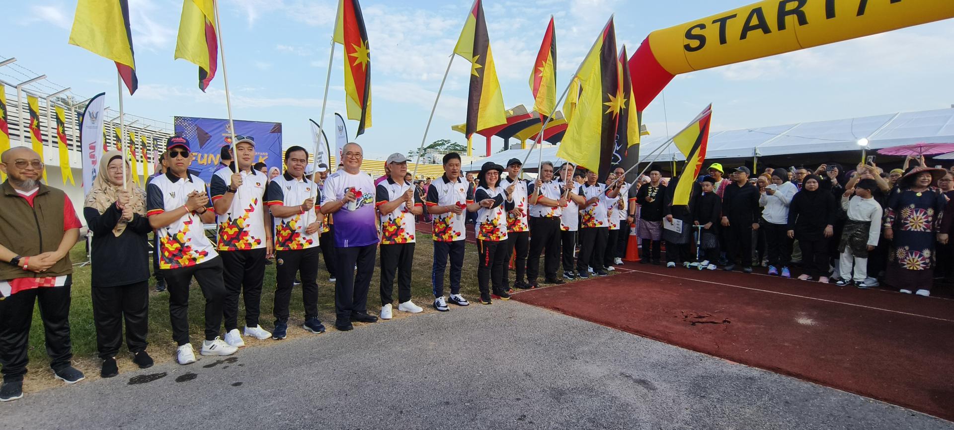 拿督里宾拉玛博士（左8）与嘉宾主持挥旗礼，为“我亲爱的砂拉越”3公里趣乐步行掀开序幕。