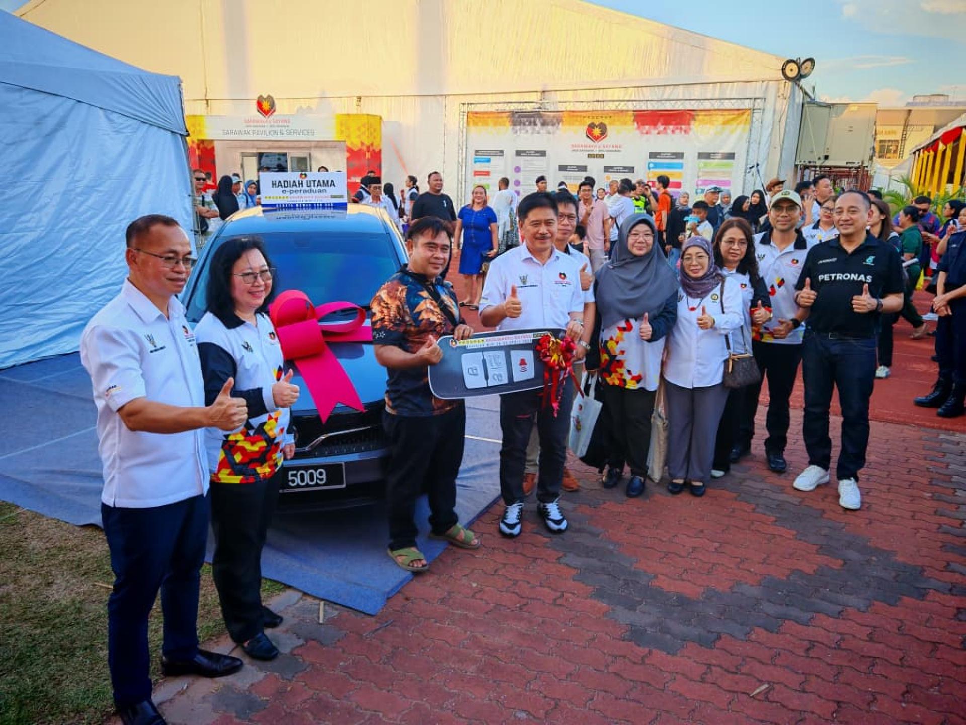 幸运得主Amdin Bin Abang Morsidi。（左3）从砂拉越青年、体育及企业家发展部副部长拿督里宾拉玛手中领取宝腾赛佳（Proton Saga）轿车钥匙。
