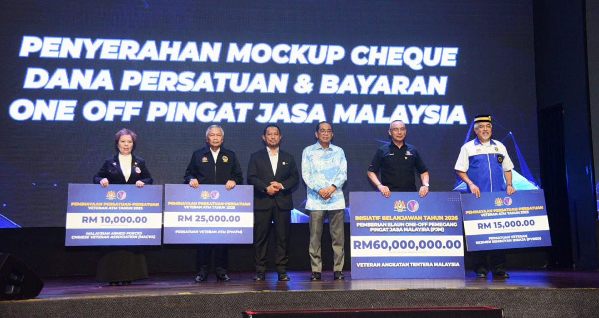 卡立诺丁（右3）与获得协会拨款及“一次性”马来西亚服务勋章款项的受惠者合影。左3为国防部秘书长拿督洛克曼。