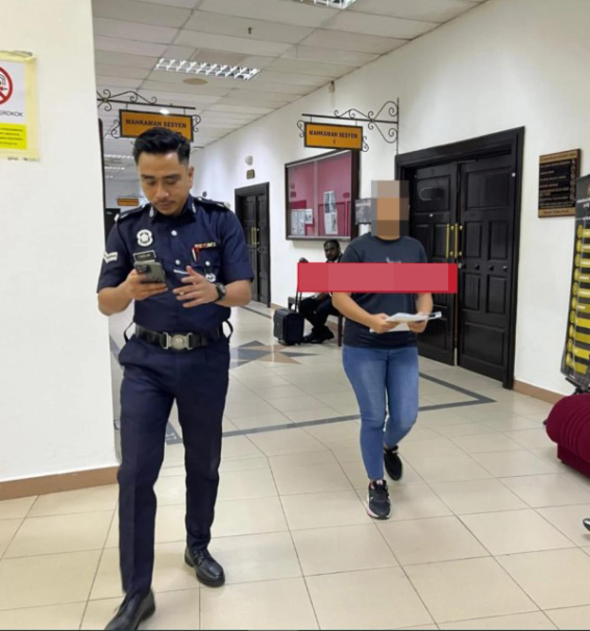 被告（右）在警员押送下离开第二地方法庭。