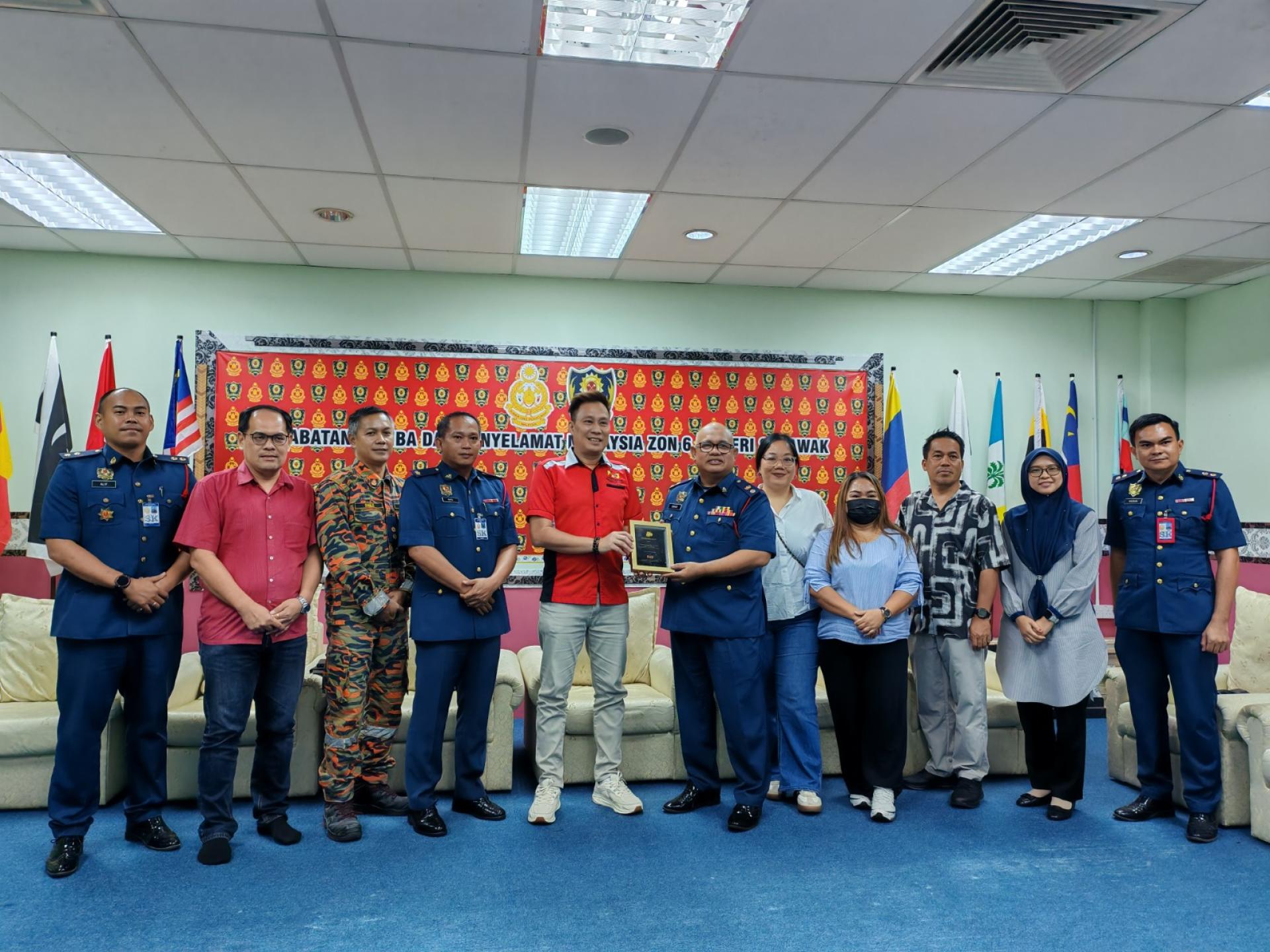 北砂新闻从业员协会会长蔡传晋（左5）赠送纪念品予砂消拯局第6区区长伊斯迈迪。