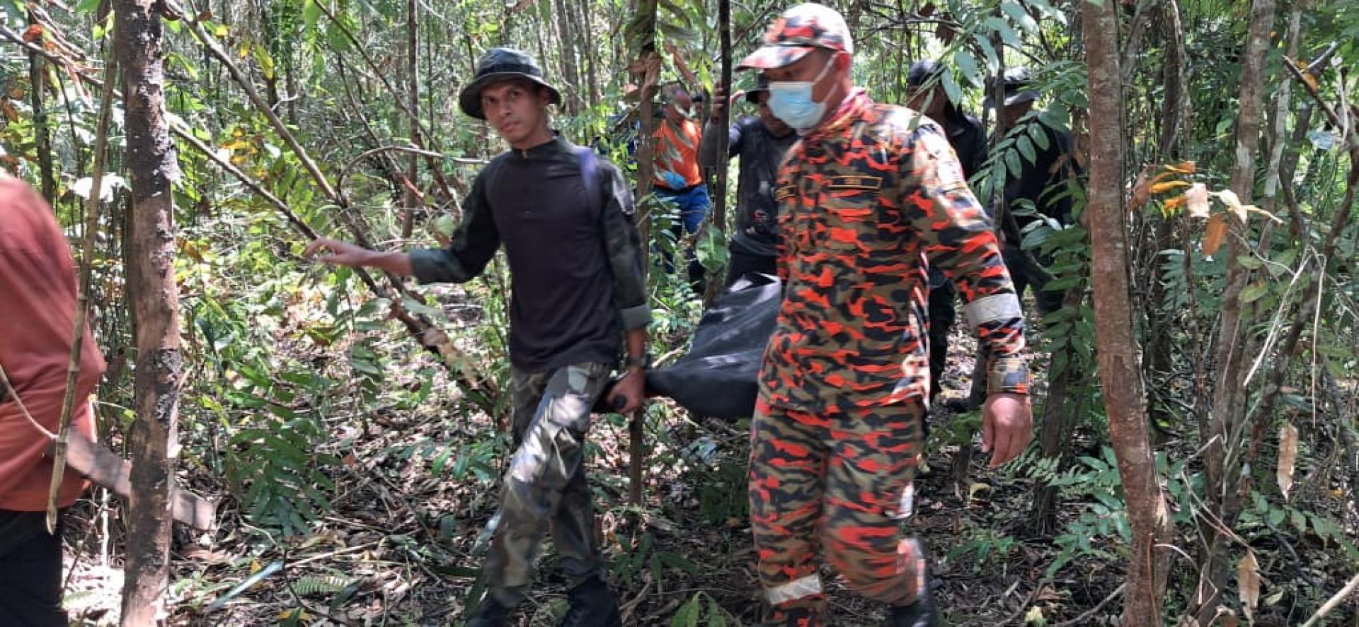 村民与消拯人员将遗体移出从林。