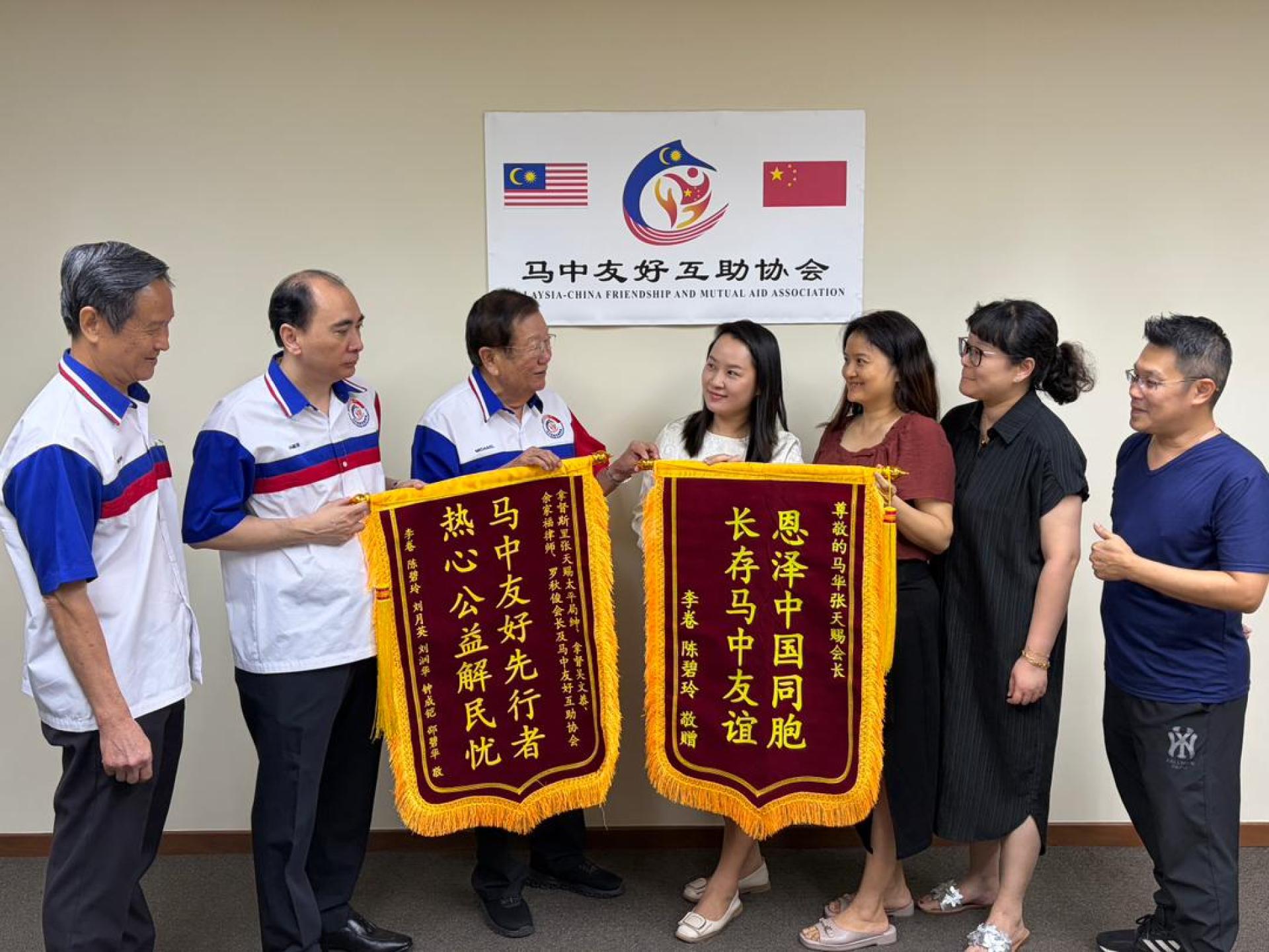 吴文恭（左起）、余家福和张天赐，获得事主等人移交锦旗，以示谢意。