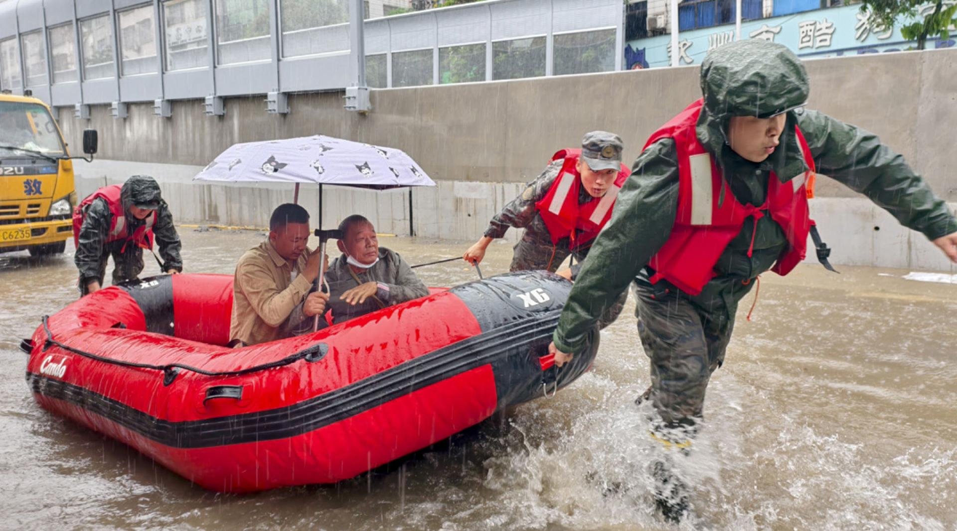 武警官兵27日在钦州市用冲锋舟将需要就医的群众送往附近的医院。（图：新华社）