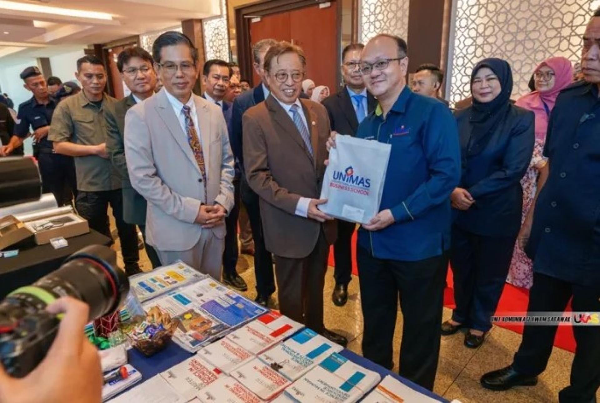 阿末哈塔（左）陪同阿邦佐哈里（中）参观展览区。