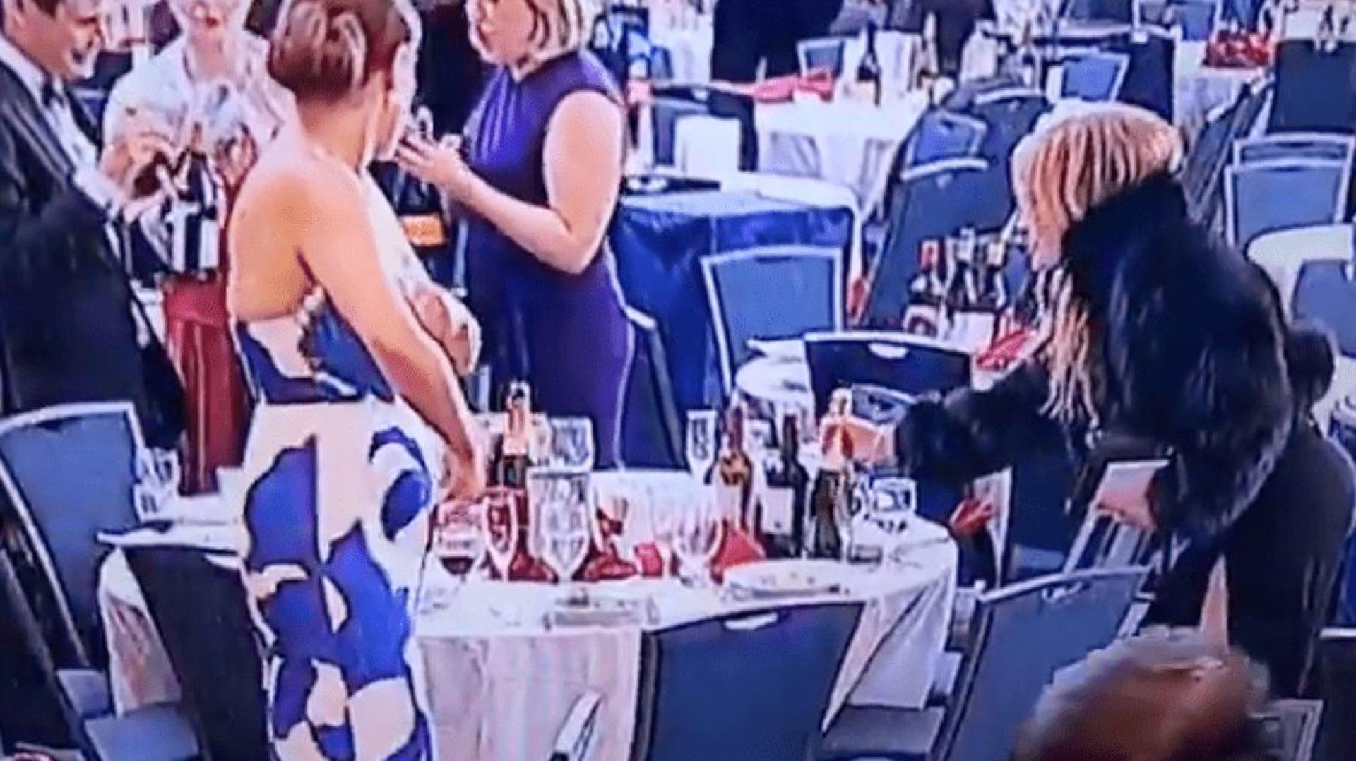 女宾客“顺手牵羊”先从餐桌上拿走一瓶香槟。