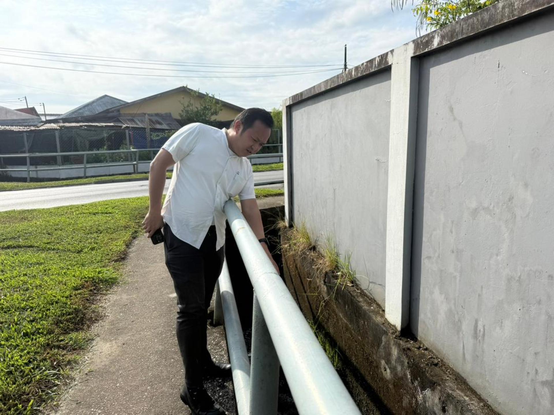江峰年视察其中一条沟渠。