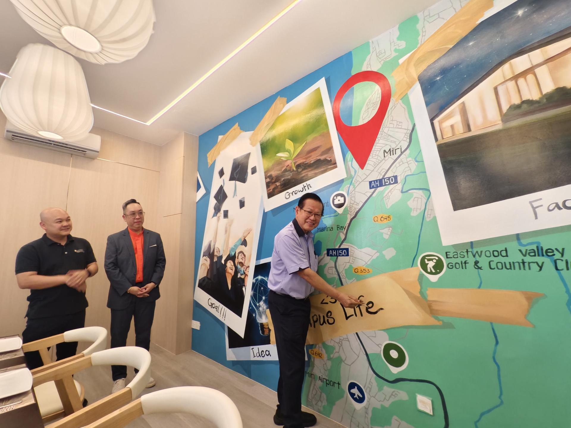 砂拉越交通部长拿督斯里李景胜在马来西亚科廷大学校长李健全（左）及Interhill Hospitality餐饮业副总经理谭兆雄（左2）陪同下，为“Faculty of Makan”标志性壁画进行最后润色。该壁画以成长、知识与社区为主题，不仅是装饰艺术，更象征咖啡馆与科廷大学马来西亚分校青春创意精神的紧密联系。