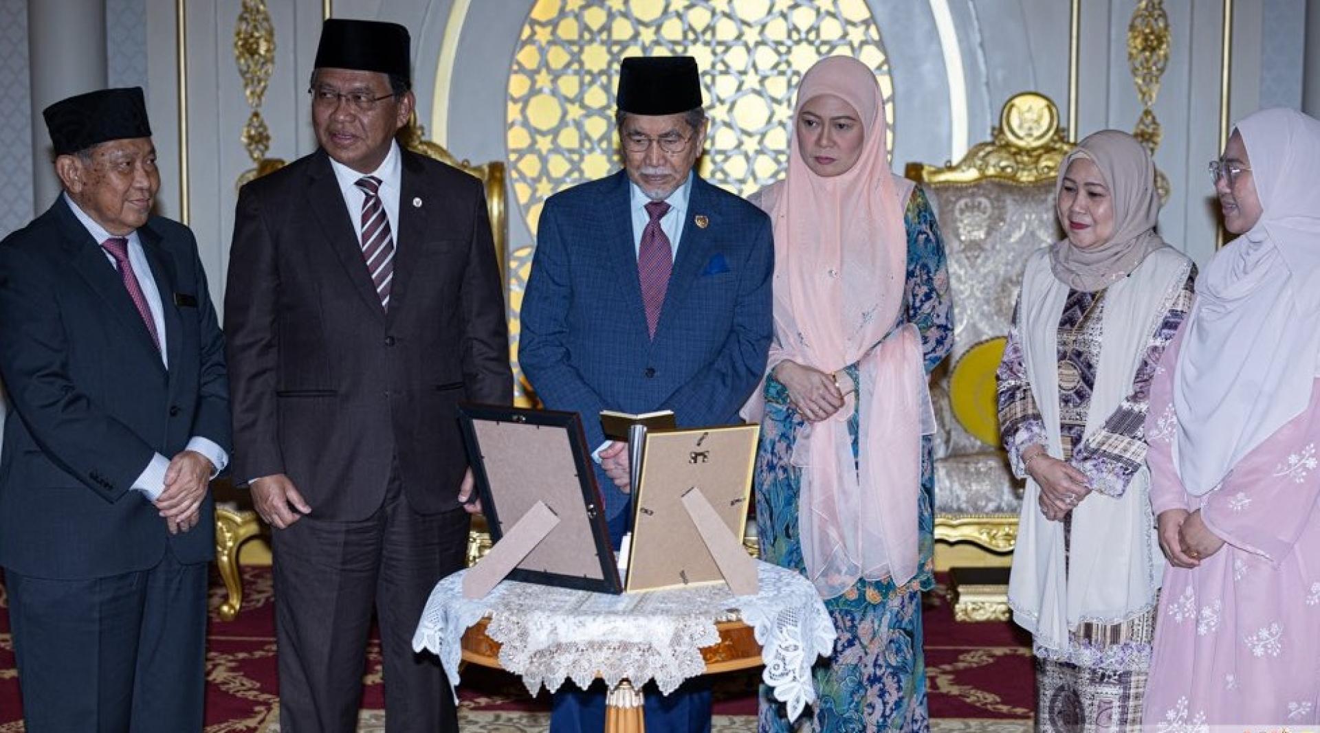 砂元首敦丕显斯里旺朱乃迪与夫人（中）欣赏砂代表荣获的全国古兰经诵读及背诵大会冠军奖杯。