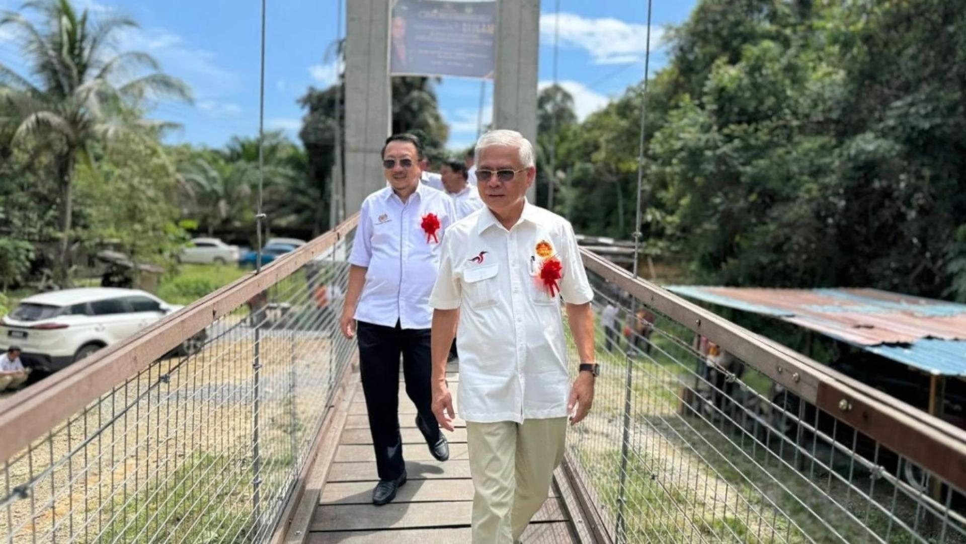 奥马尔（左）与弗莱迪行走在新桥上。（图：砂拉越教育局）
