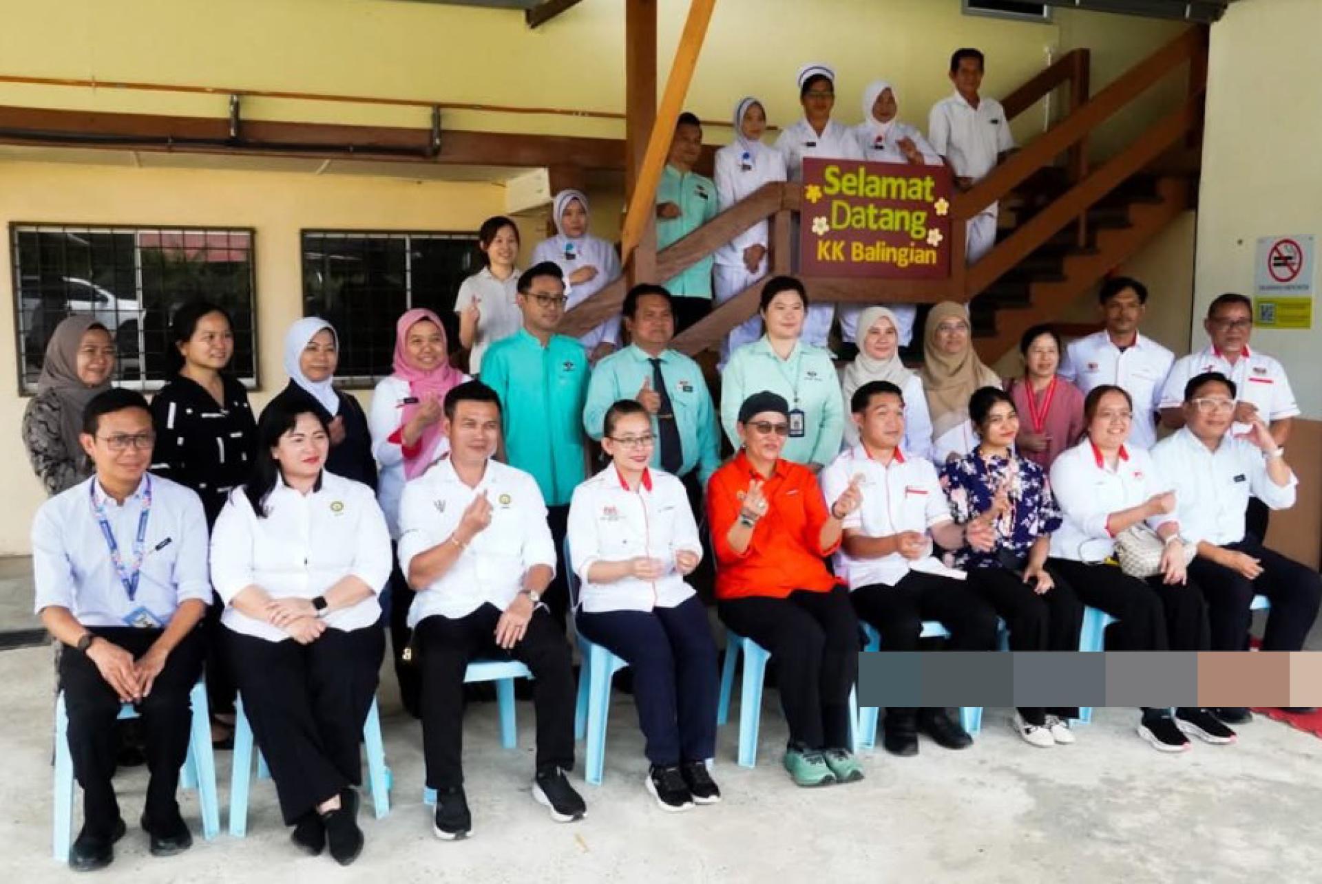 哈妮法（中坐）与万年烟诊所职员合影。（图：UKAS）