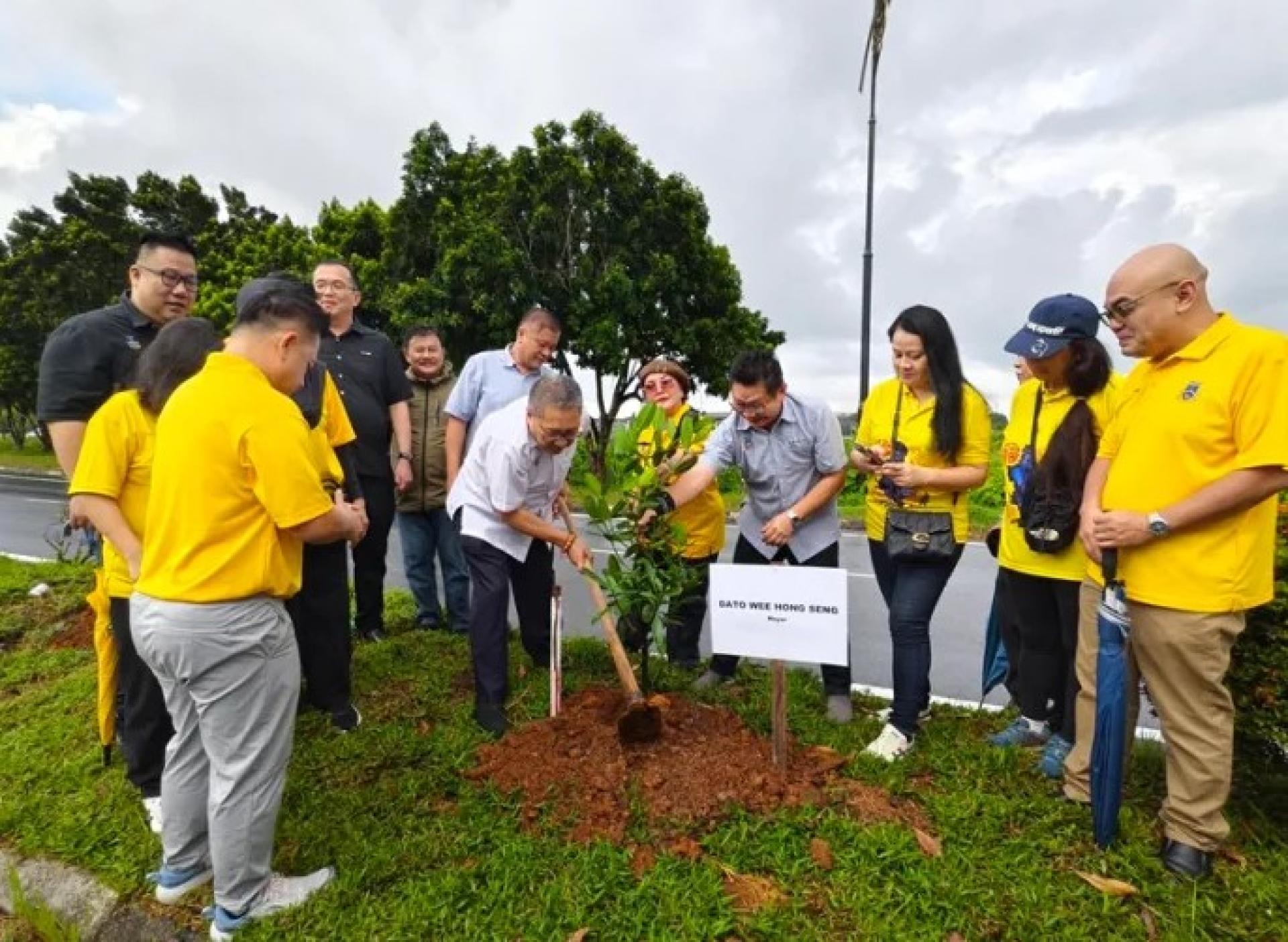 黄鸿圣（右5）与南市市局职员于2026年4月30日在舍里普玛沙霍路种植“幸福树”。