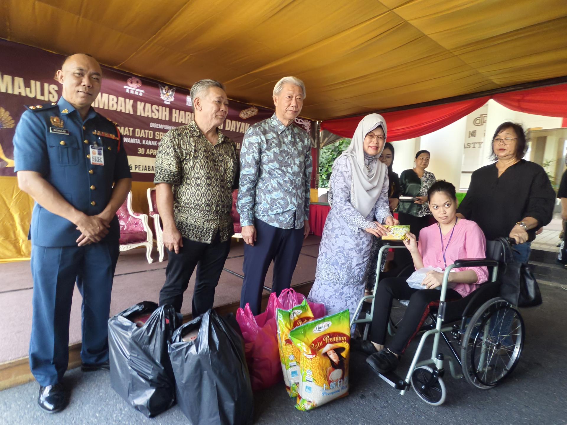 砂妇女、儿童及社区福祉发展部部长拿督斯里陈赛明（左4）移交达雅节援助金与生活必需品礼包予受惠者。左3为贝园酒店董事经理贝清湛。