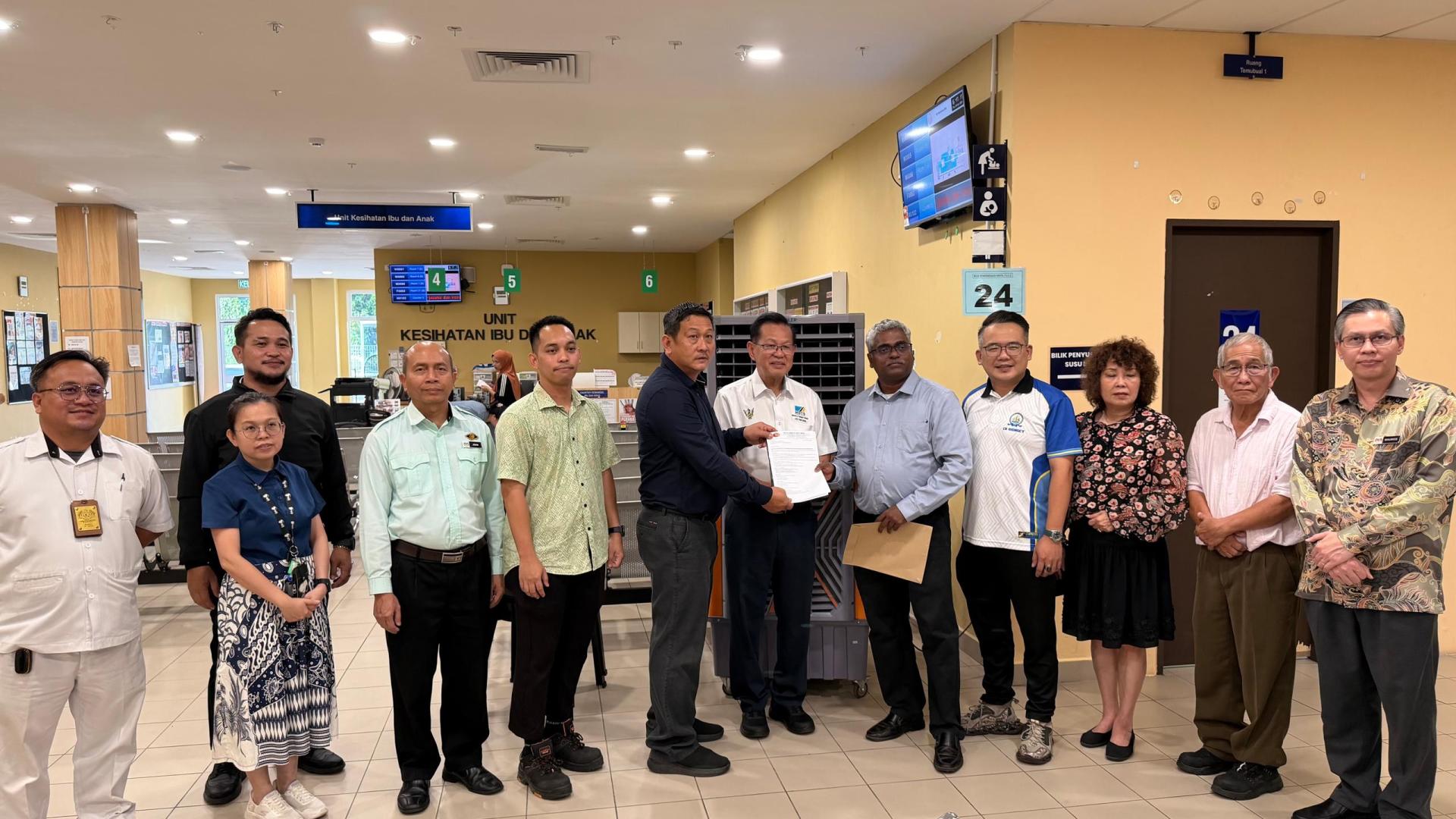 志愿企业社会责任（CSR）代表移交空调维修建议书予美里省卫生局局长拉威医生（右5）。