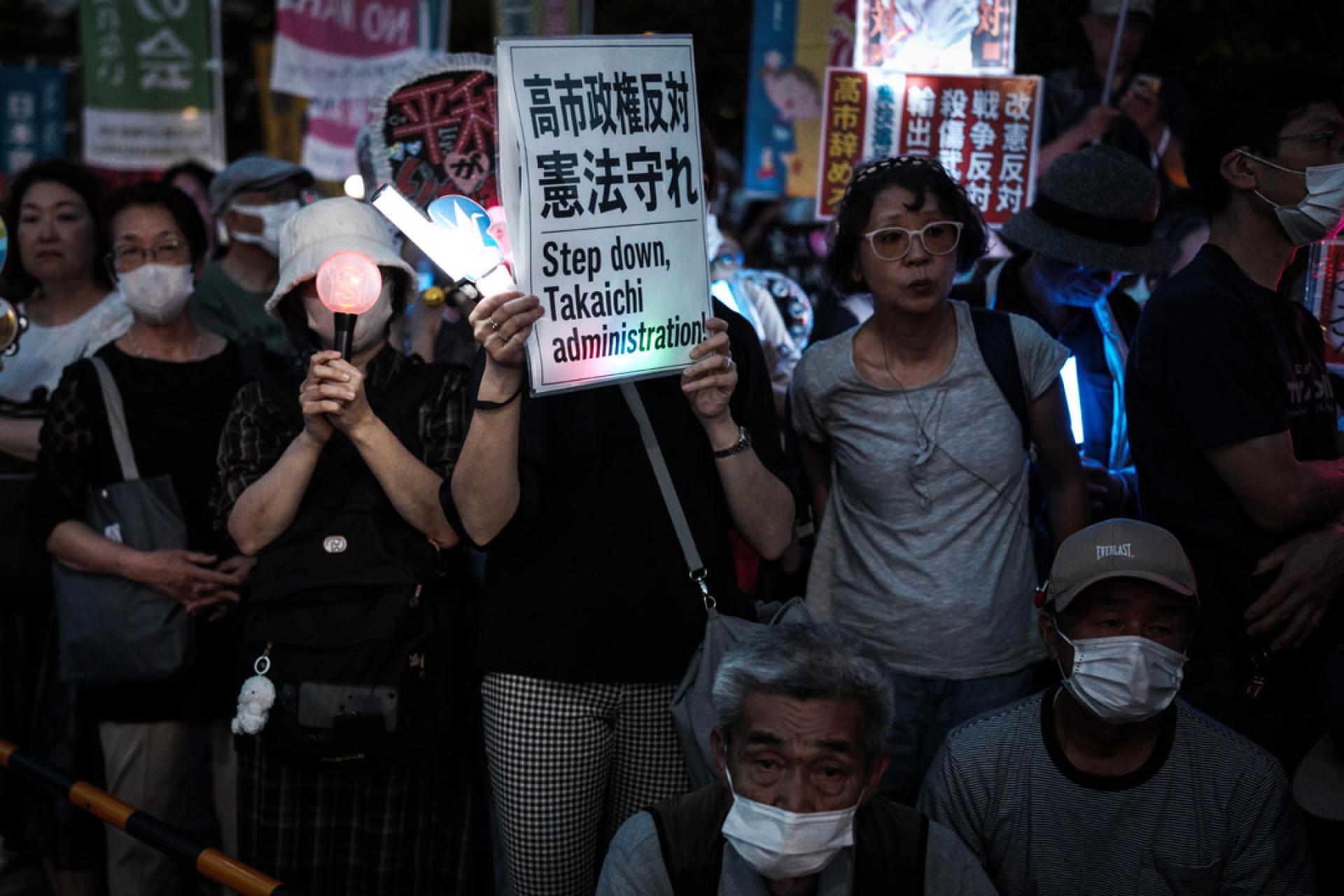 民众手持标语参加抗议集会。(图：新华社)