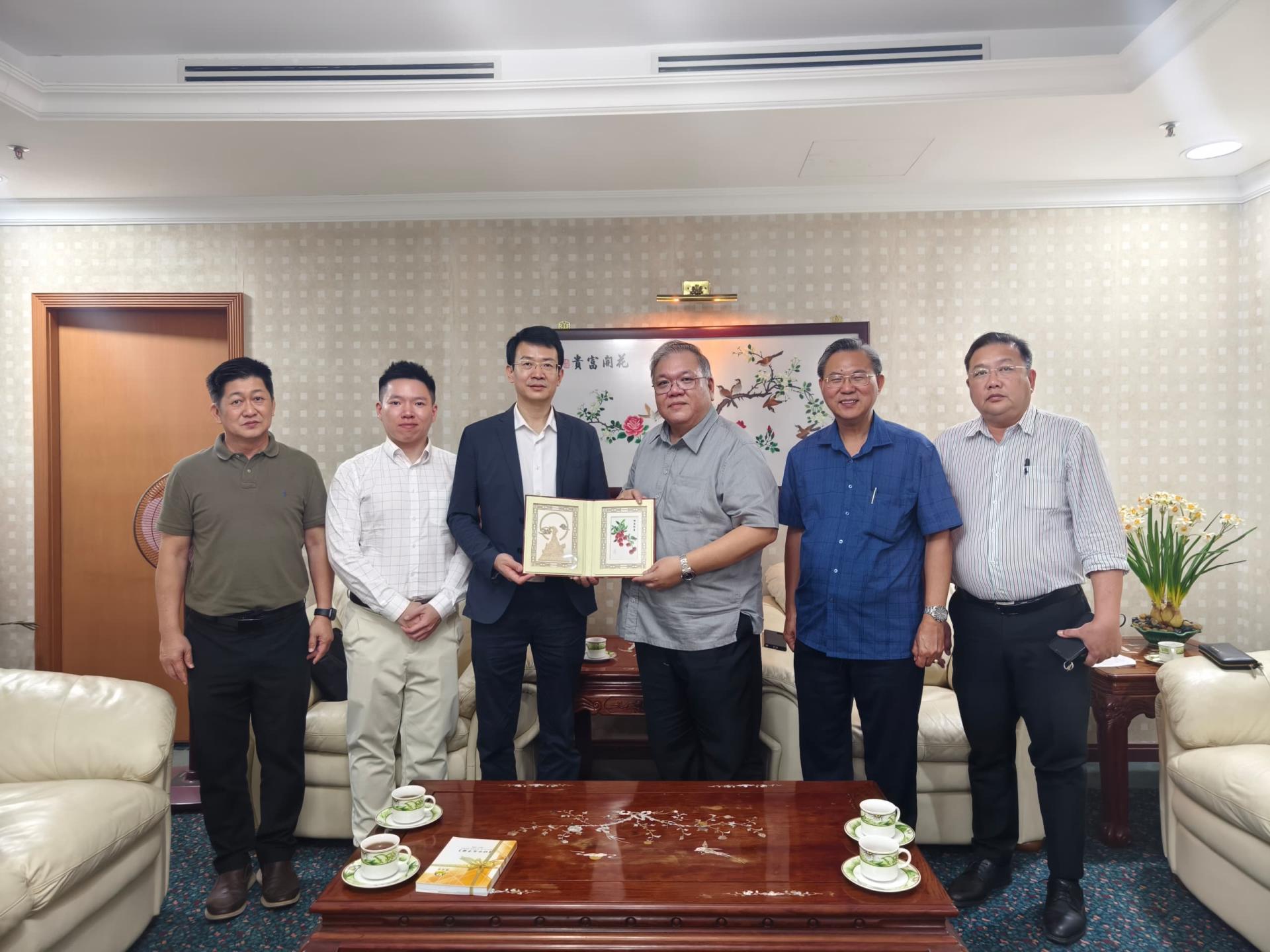 广东省驻东南亚（吉隆坡）经贸办事处主任张君宏（左3）赠送纪念品予砂中总副会长拿督黄国辉（右3）。左1起为商业组副主任蔡明龙、广东省驻东南亚（吉隆坡）经贸办事处副主任许凯映。右1起为砂中总数字经济组主任王运才、古晋中总马中经贸组主任张光福。