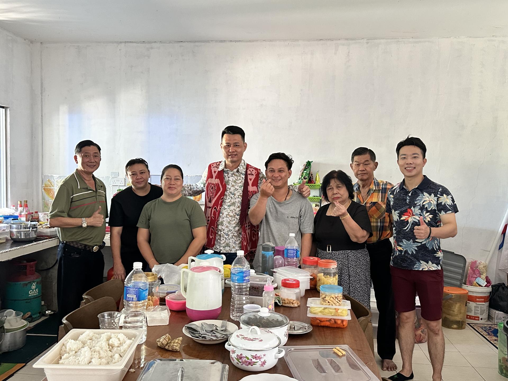 林思健（左4）到居民的家里贺年并享用佳肴后合影留念。右2是行动党巴南支部主席许义成。