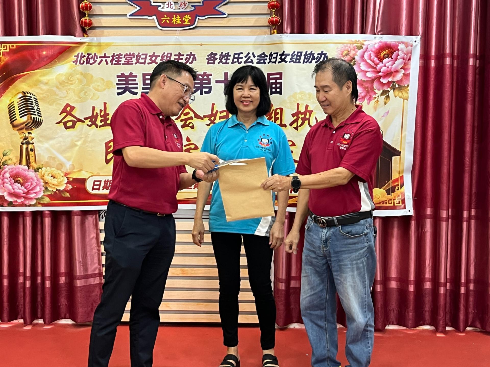 北砂六桂堂主席洪立川主持揭题仪式，右为署理主席孝胜，左2为妇女组署理主任兼筹备会主席龚世珍。