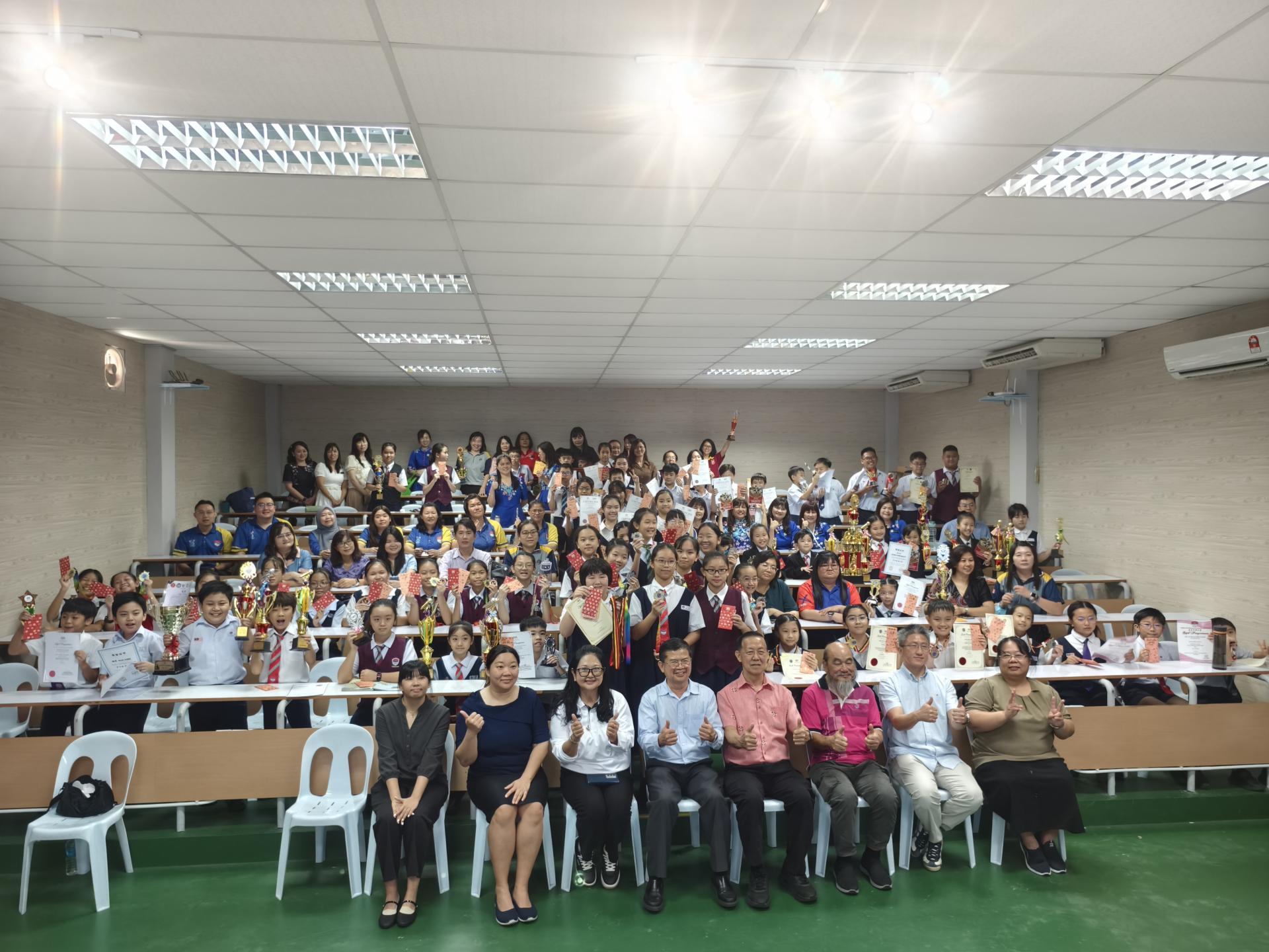 美里中华公学2026年课外活动第一季颁奖典礼圆满举行，校方与获奖学生在多媒体室合影留念。前排左3为校长陈泳伽、董事长李开运、董事财政宋志强、董事蔡明耕董事李健强，以及课外活动主任陈美英副校长。
