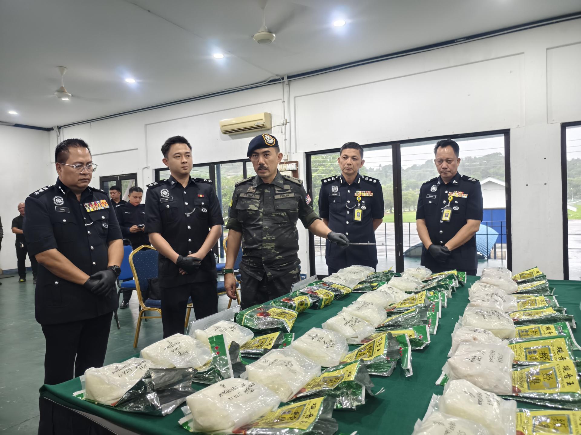 砂拉越警察总监拿督莫哈末再纳阿都拉（中）向媒体讲解案件详情，并展示起获的55公斤疑似冰毒。