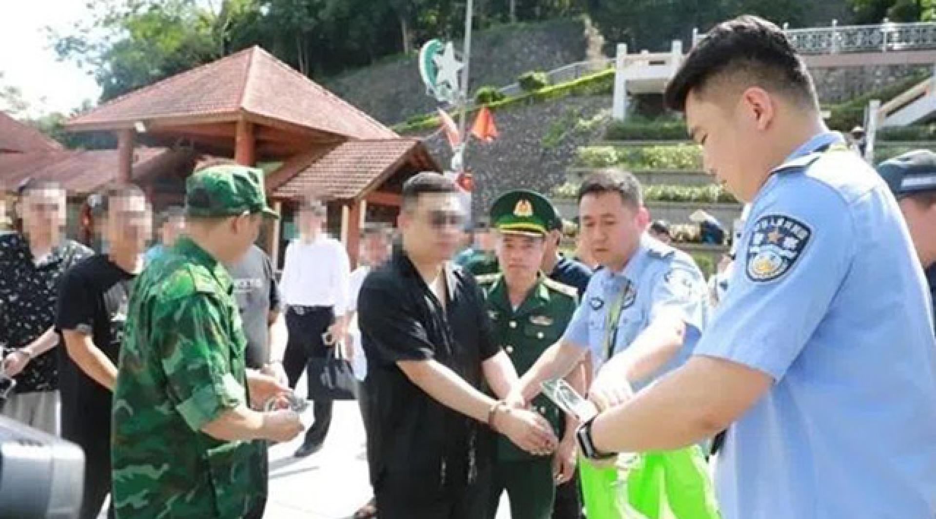 中越警方在越南现场交接被抓的涉嫌破坏电脑信息系统案潘姓首犯（中）。