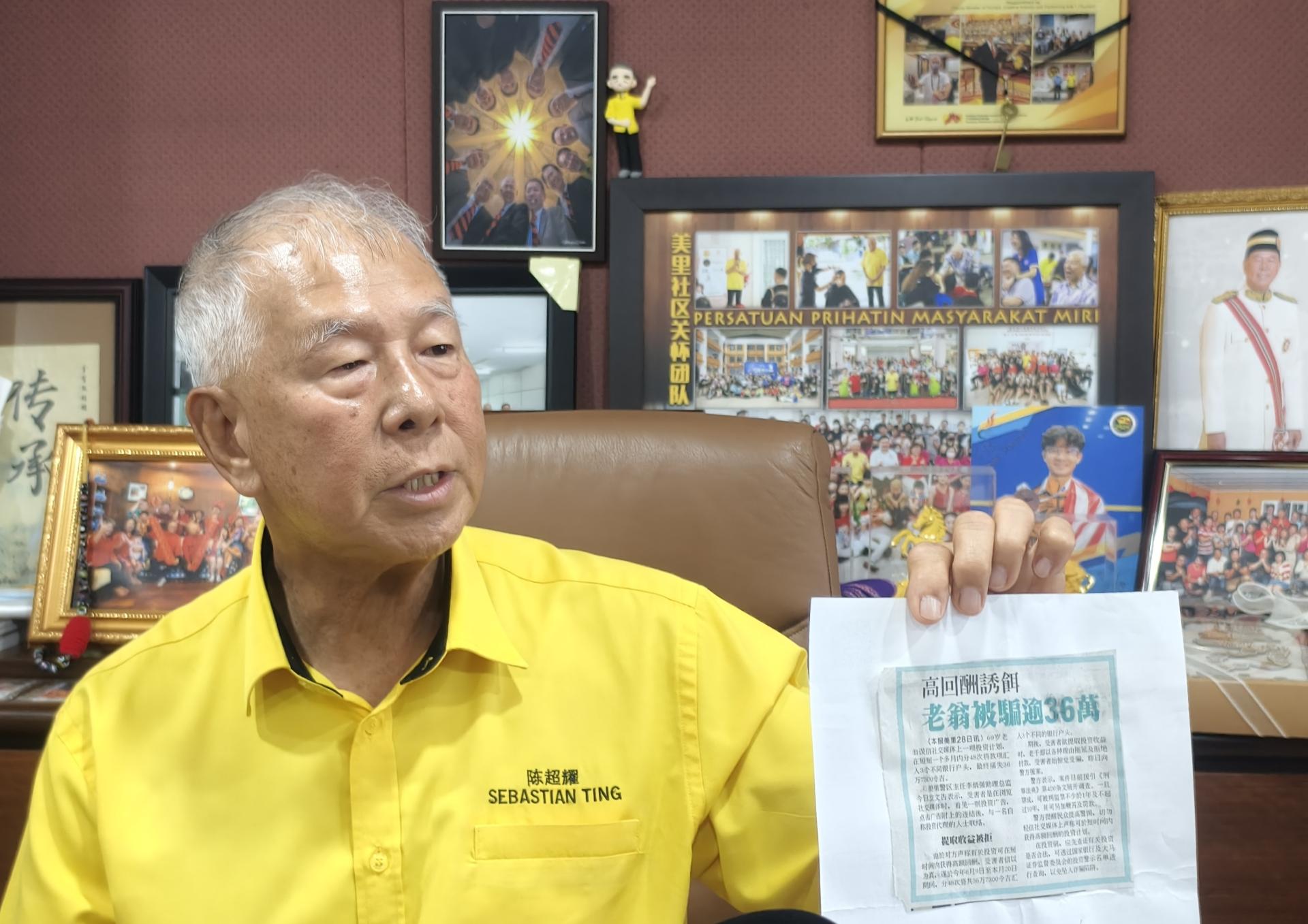 拿督陈超耀向媒体展示各报章有关高回酬诱饵报导剪报。